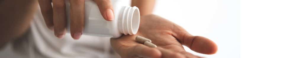 woman holding supplement capsules